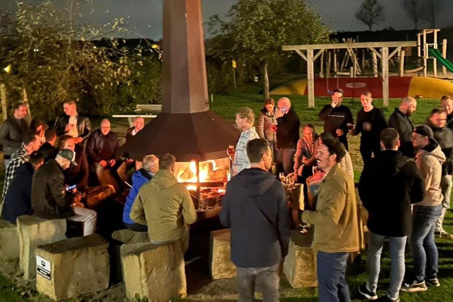 Gasten rond het kampvuur bij de stokerij, 's avonds