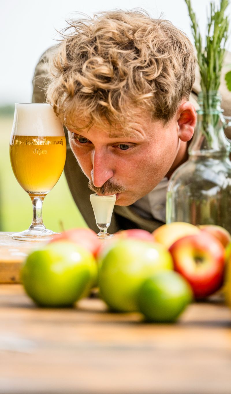 Jop slurpt de kop van de borrel, met een glas bier ernaast
